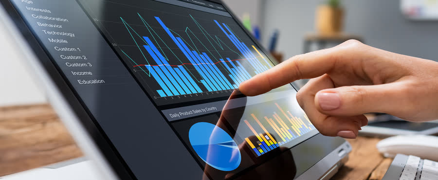 Hand reviewing campaign analytics dashboards on screen