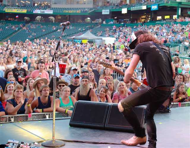 Performer on stage over a stadium crowd at K105 Country Fest